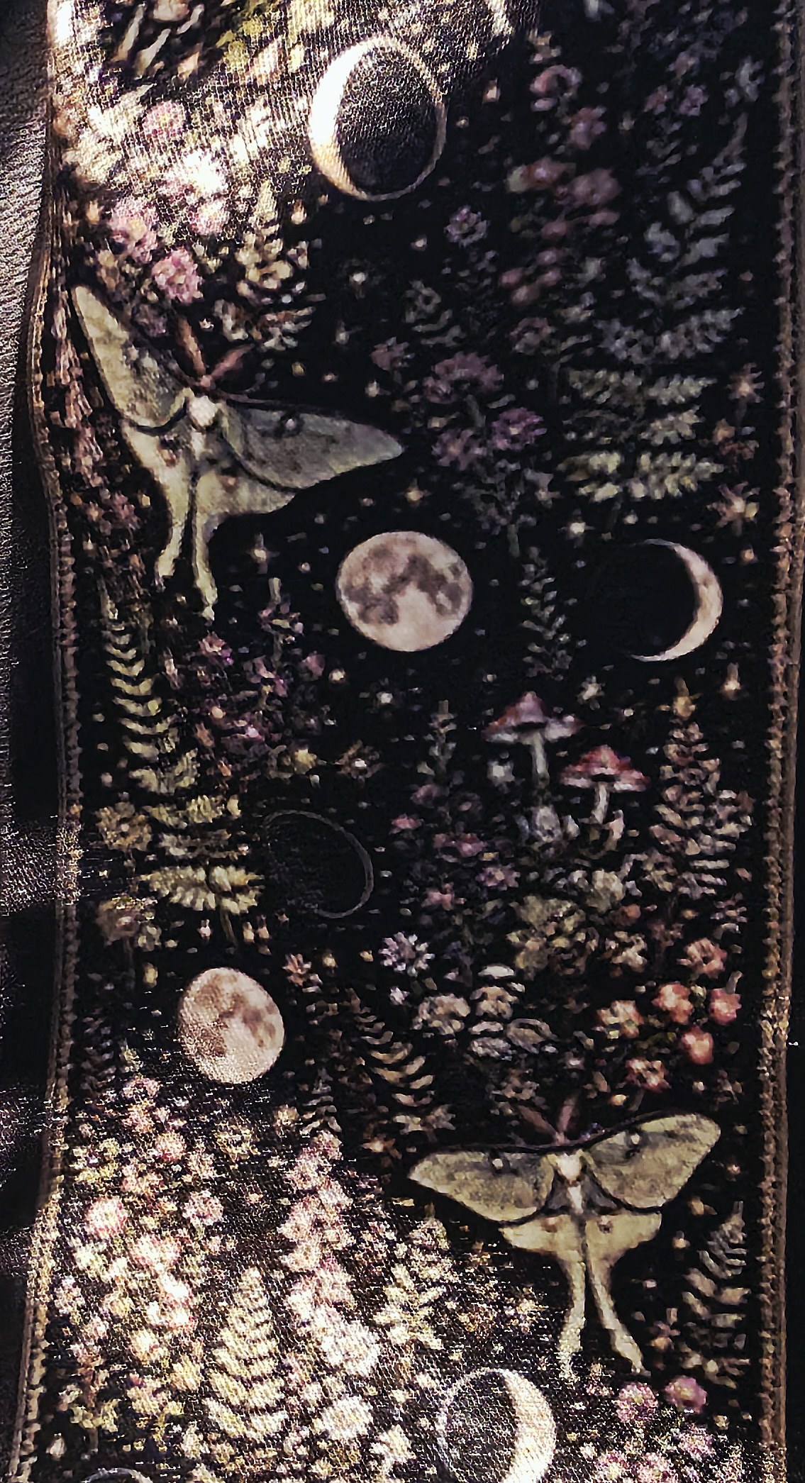 Close view of the twilly's original artwork- luna moths and moon phases among ferns, mushrooms, and wild blossoms on a midnight ground